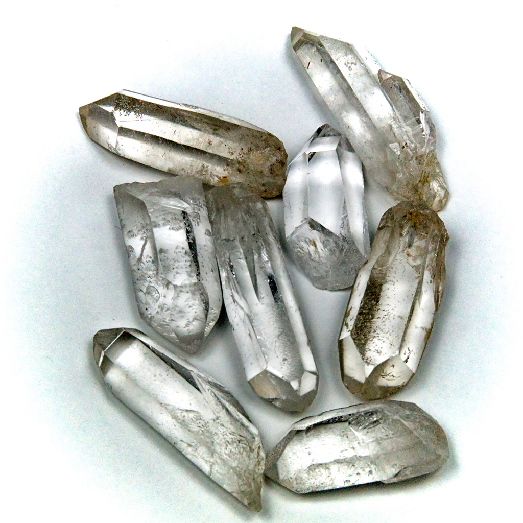 clear quartz crystal points in various shapes, raw and polished