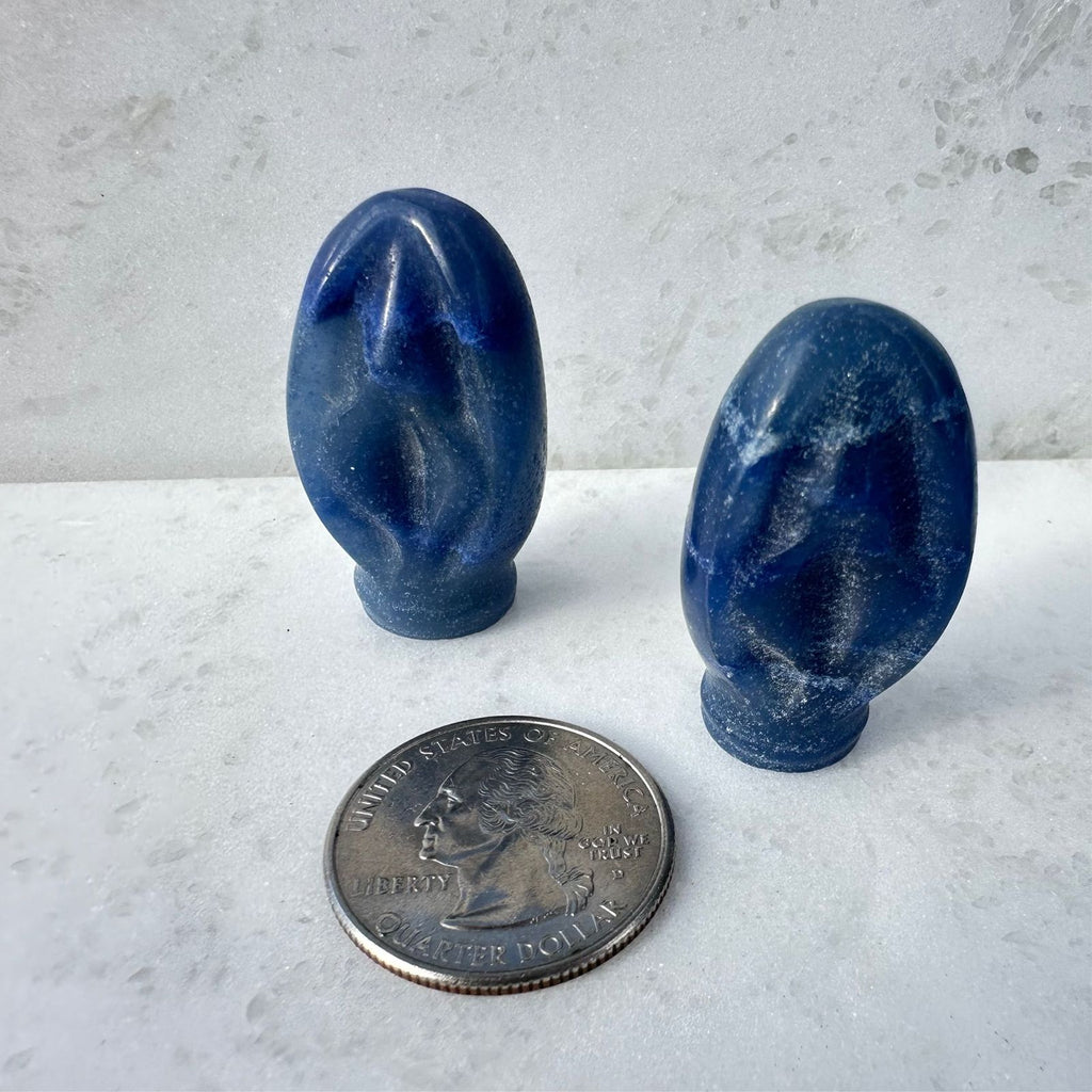 Blue Quartz crystal Portal to Paradise, crystal vulva carving, next to a quarter for size reference