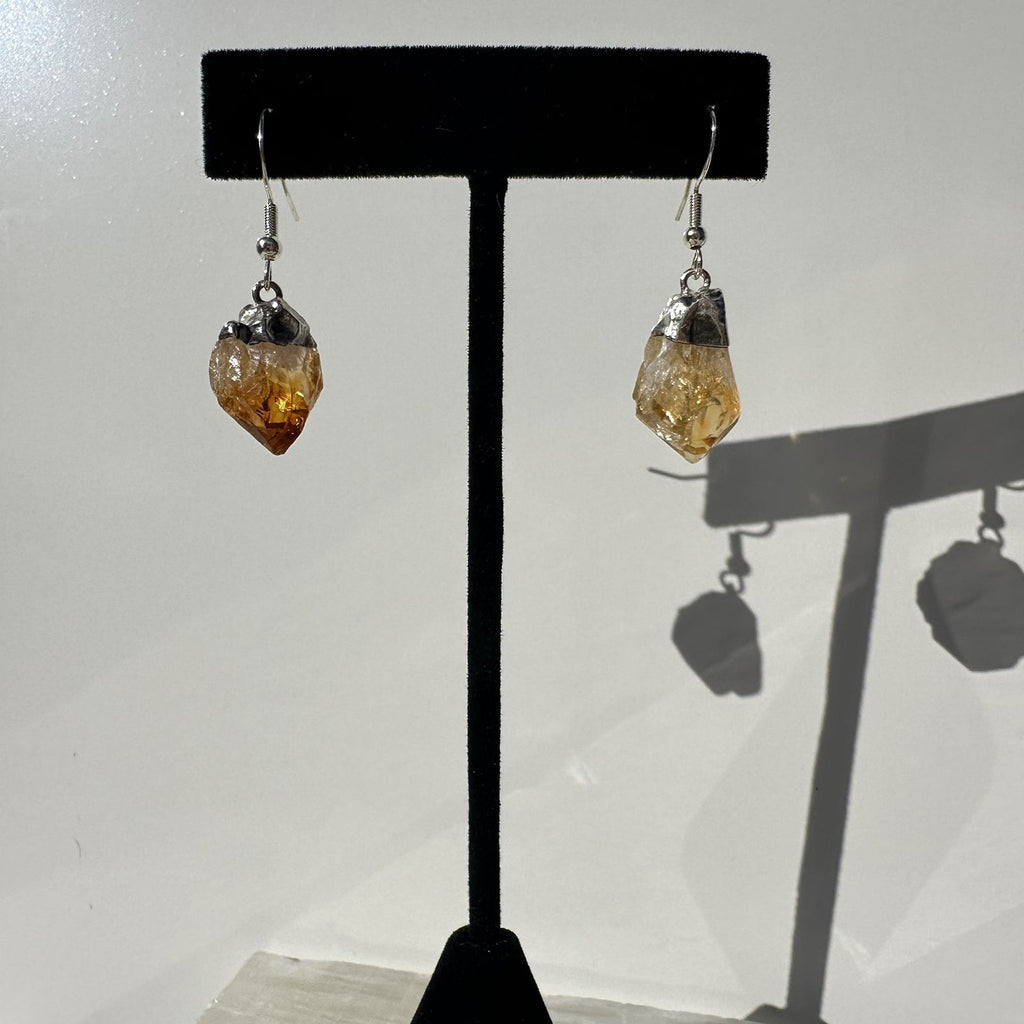 Raw Citrine dangle earrings from Brazil on a stand
