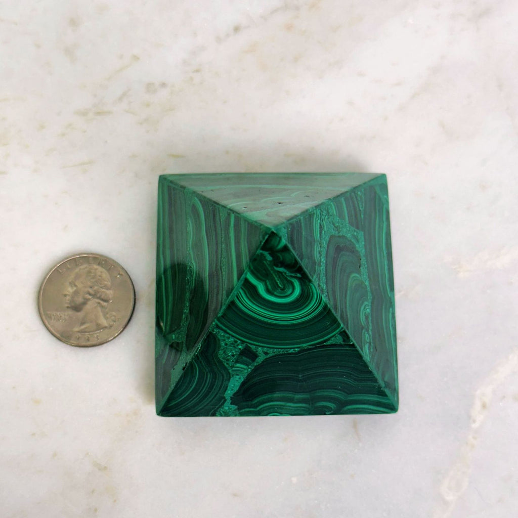 overhead view malachite pyramid with quarter for size reference