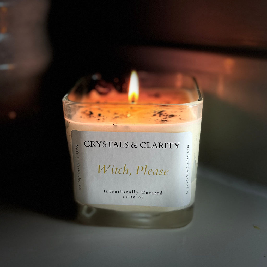 Witch, Please candle lit creating a warm glow among the black tourmaline and raw amethyst crystals.