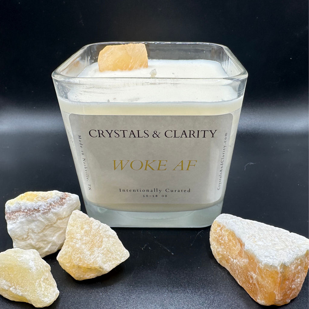 WOKE AF candle with pieces of raw Orange Calcite in front of it. 