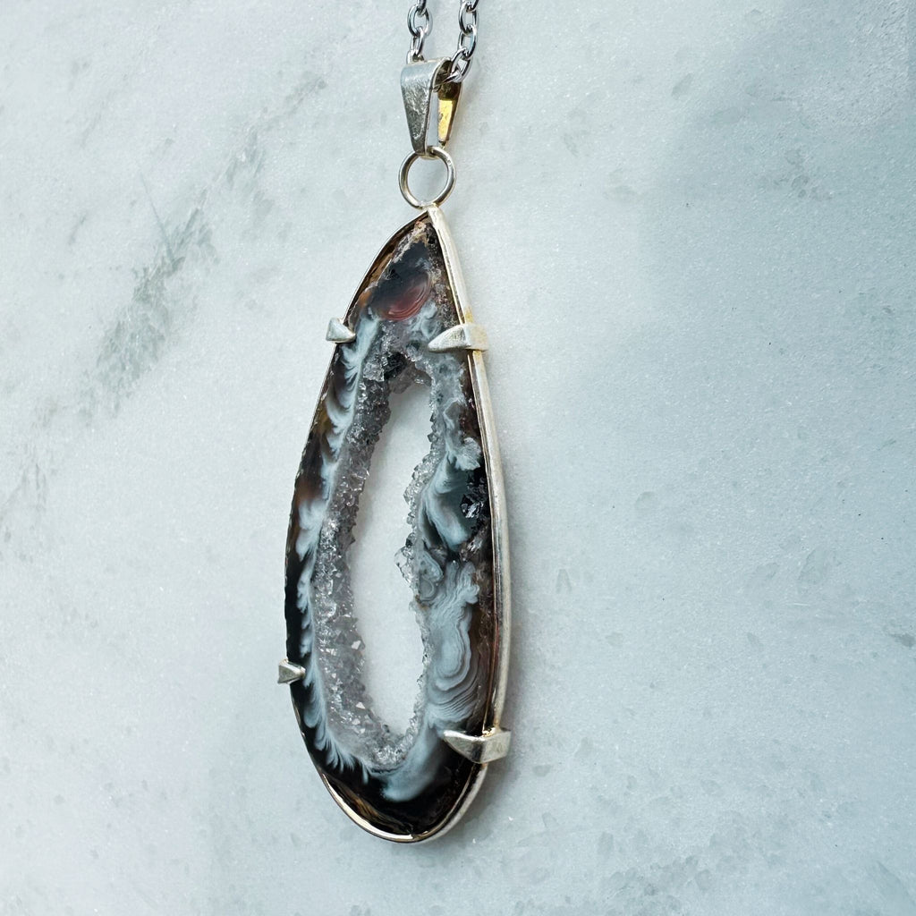 Black, Brown and White agate geode slice framed crystal necklace, side view