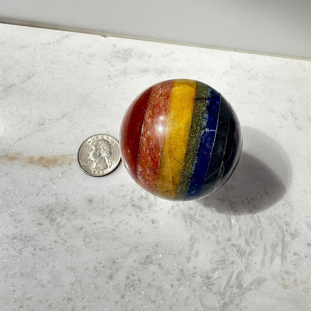 chakra sphere crystal next to a quarter for size reference