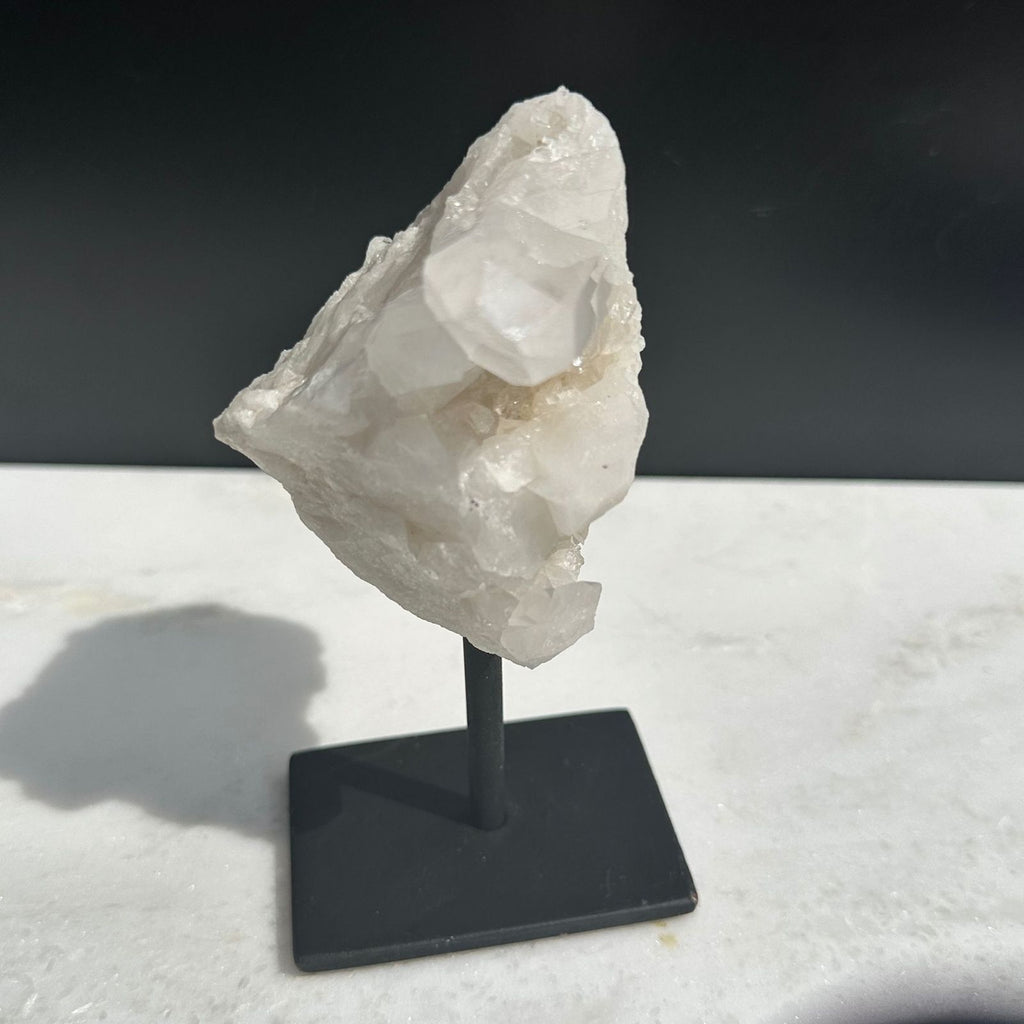clear quartz cluster with point crystals on a stand