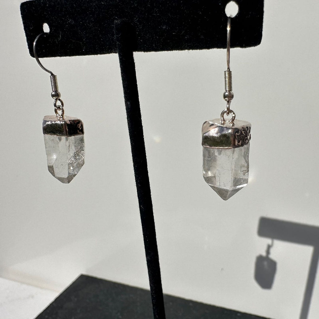 Clear Quartz dangle earrings on a stand