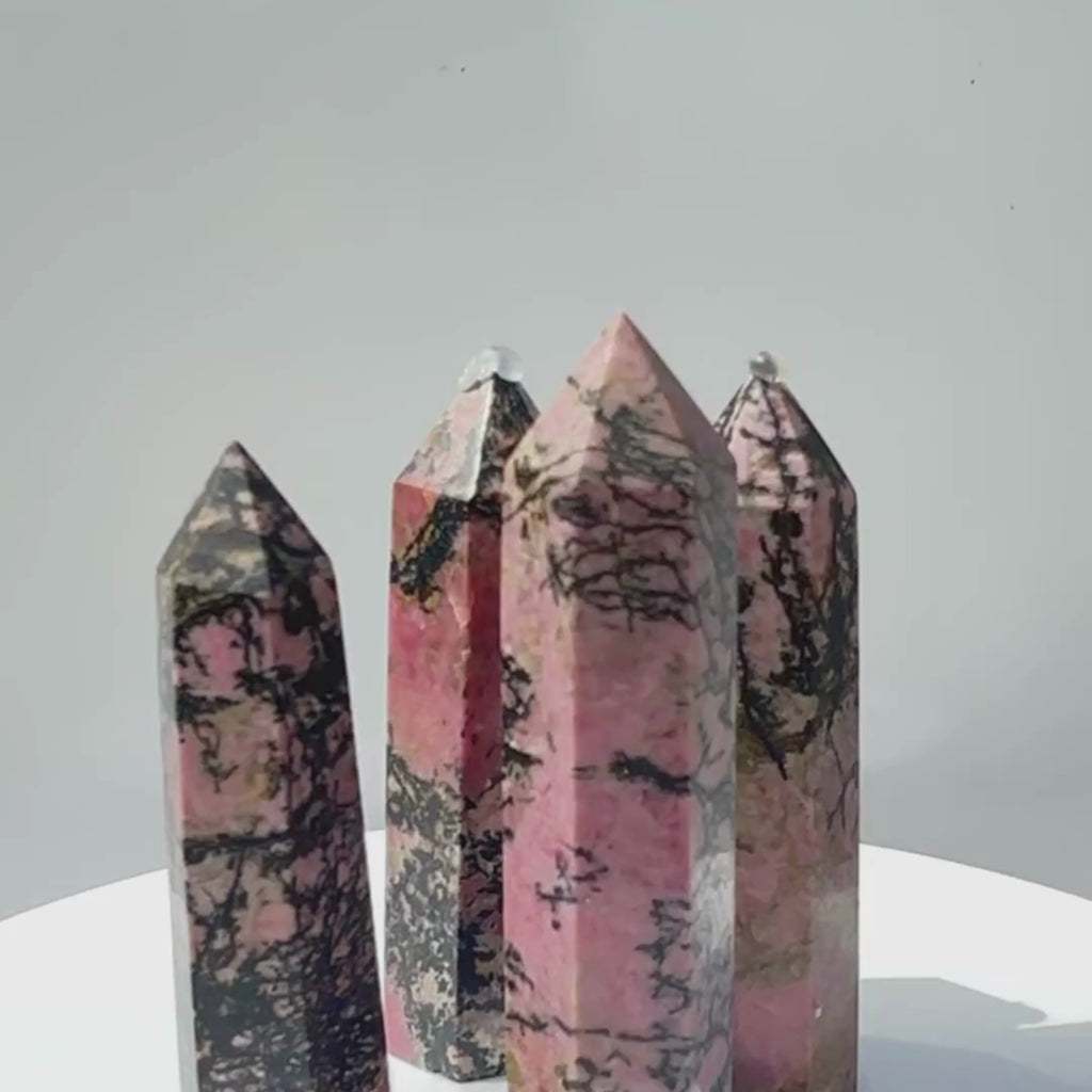 Rhodonite crystal towers slowly spining in a circle for detailed display of the crystals