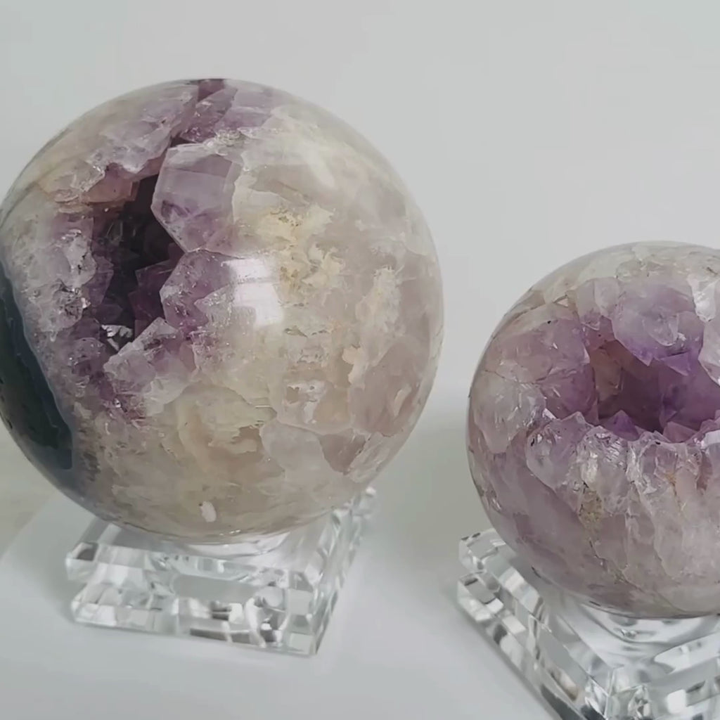 video of two amethyst cluster spheres rotating