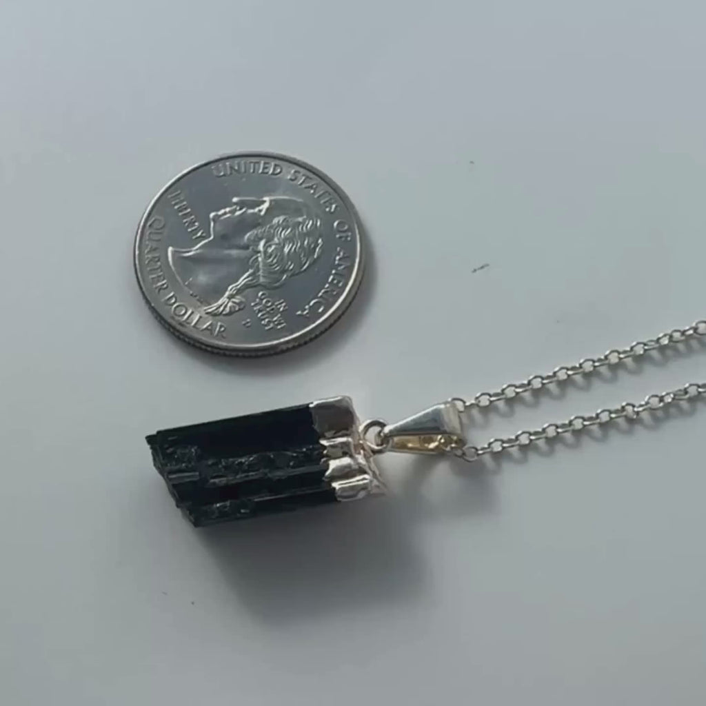 Raw black tourmaline pendant on a rotating display