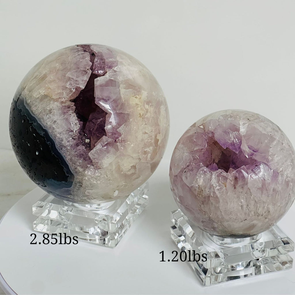 two amethyst cluster spheres with different weights